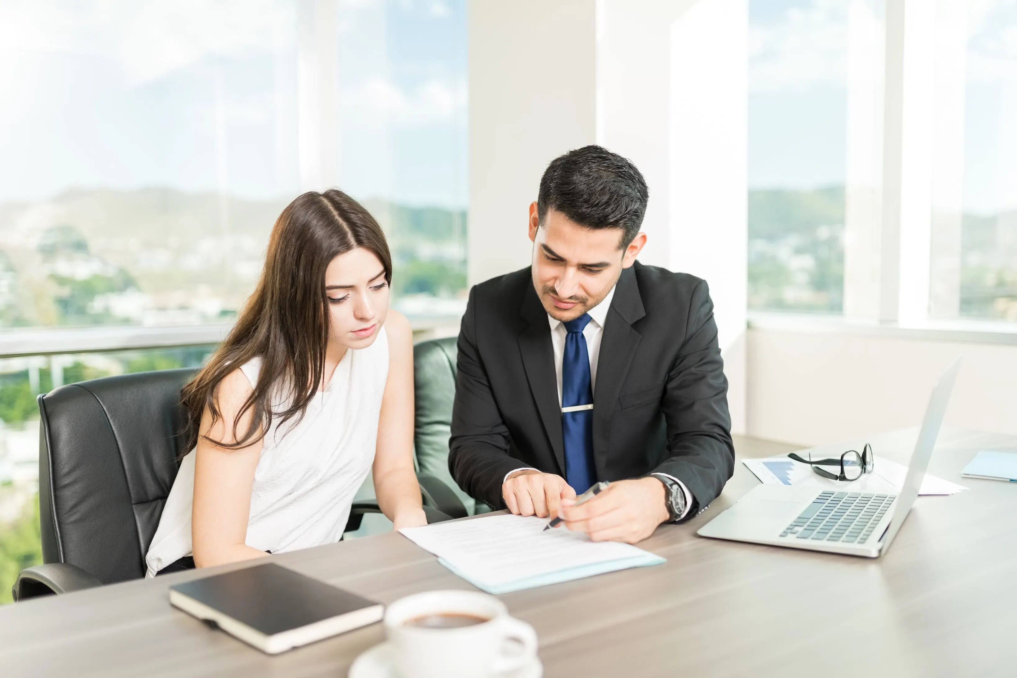 Imagen de dos personas revisando un contrato para firmarlo.